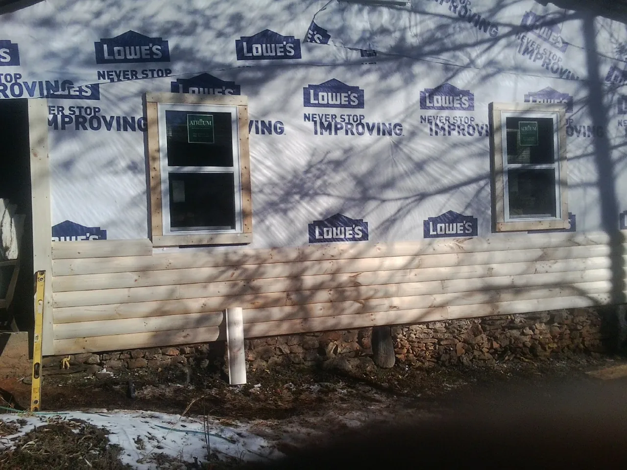 House wrap and new log siding going up on an exterior wall in Dayton